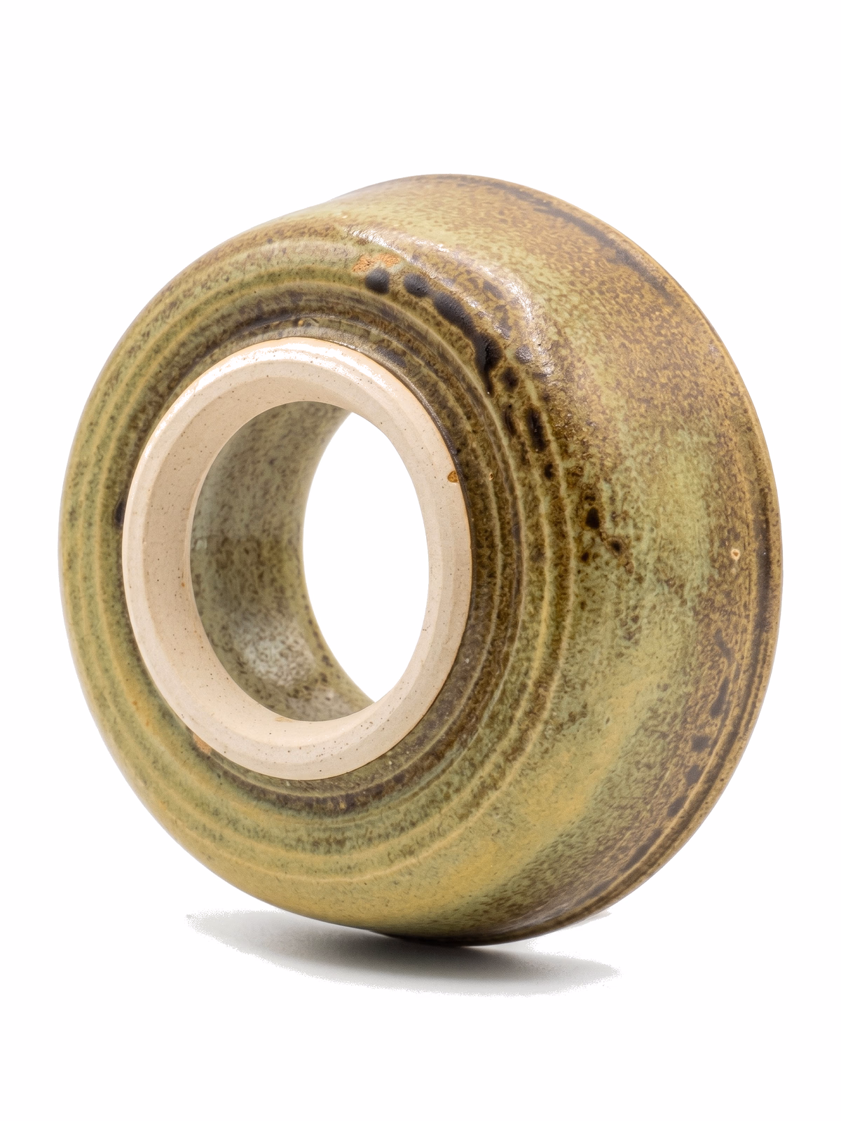A round, doughnut-form ceramic sculpture with olive-green ash glaze and dark iron streaks.