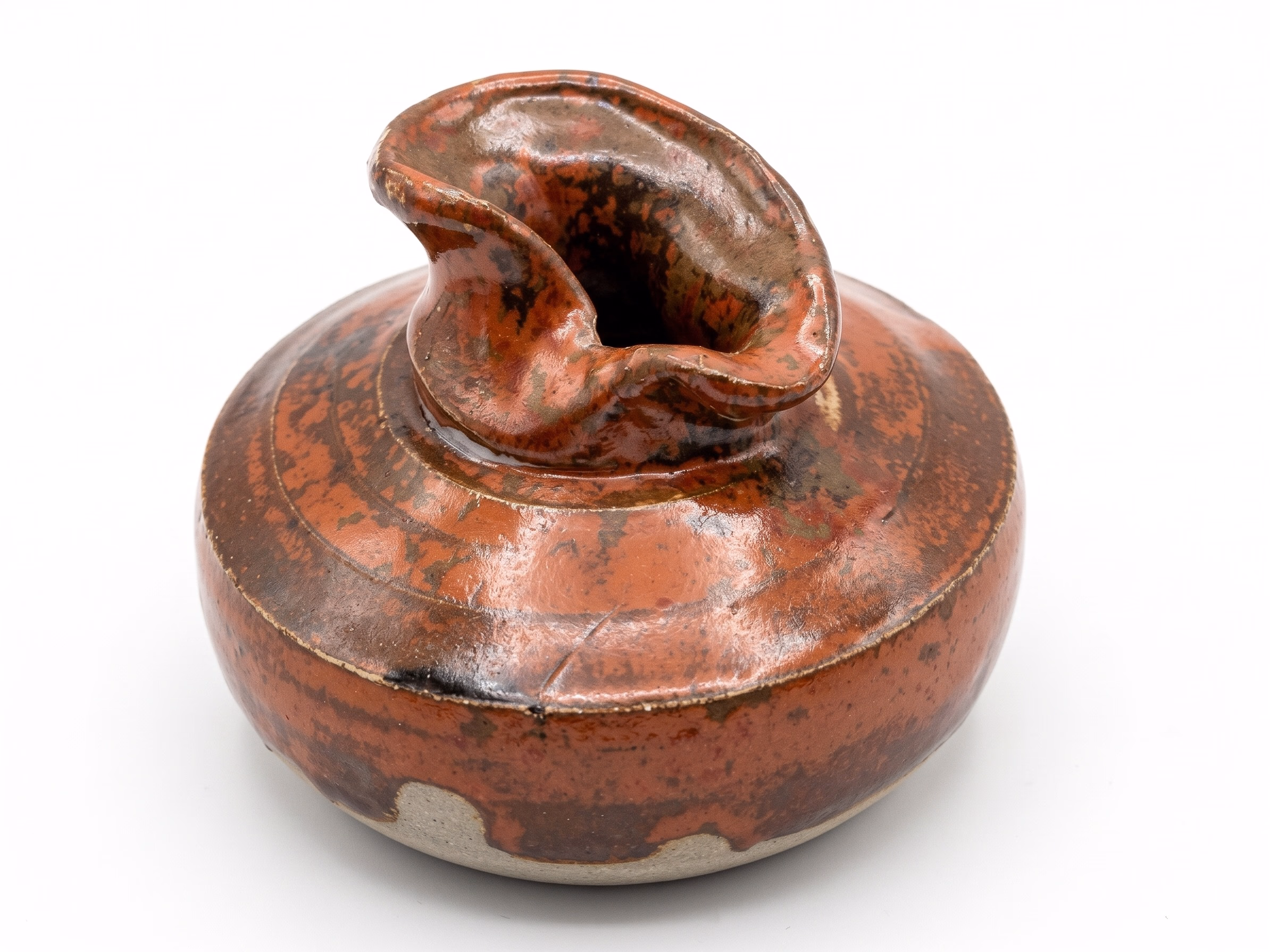 A wide low-shouldered iron-red vessel with a sculpted curled spout/lip on top.