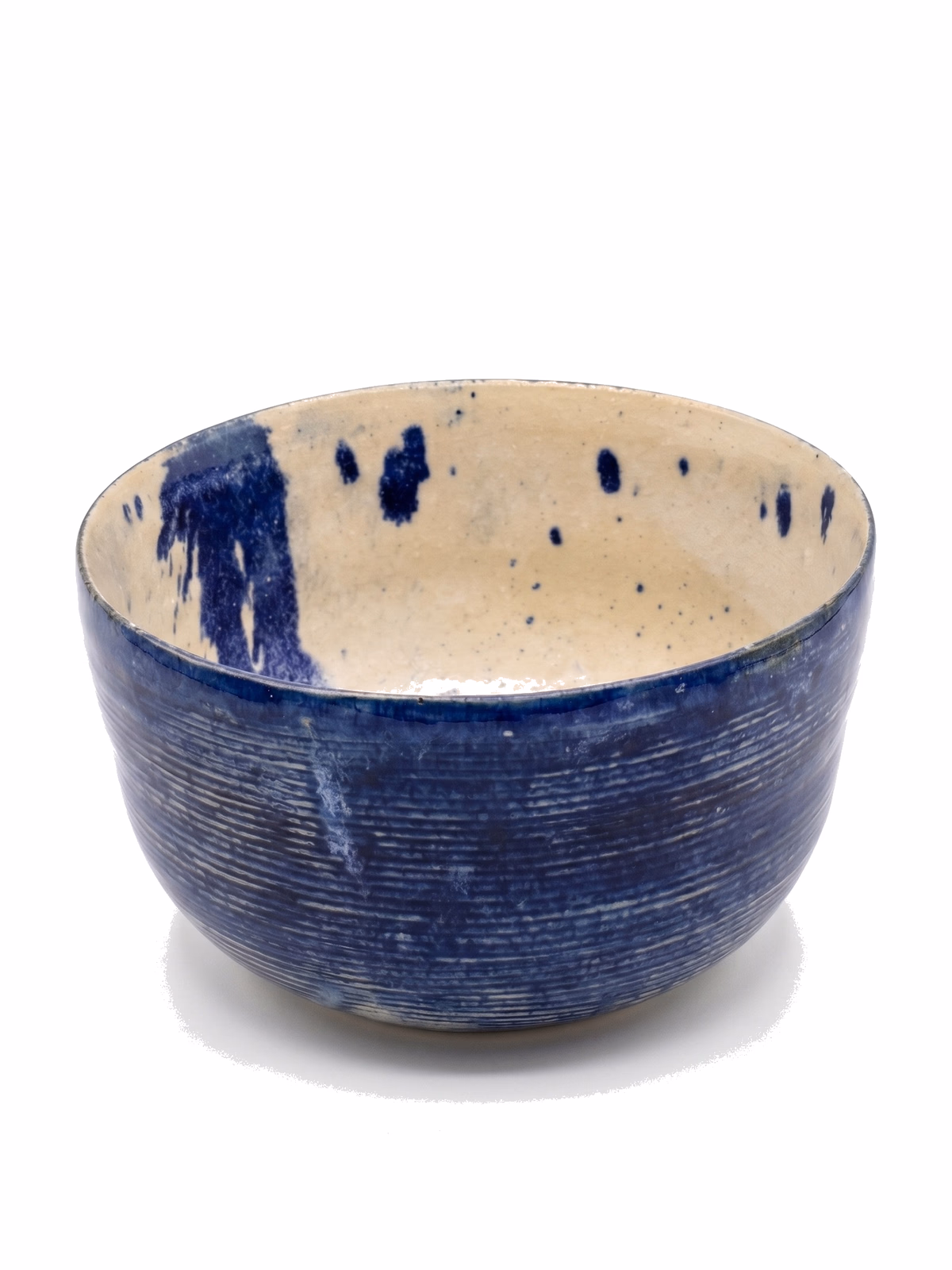 A deep ribbed stoneware bowl with cobalt-blue exterior and cream interior dripped through with navy.