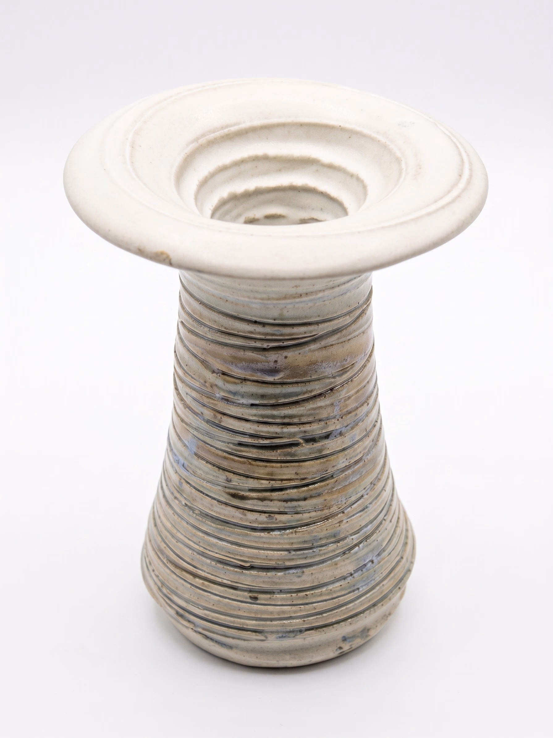 A tall vase with deep horizontal ribbing on a tapered body and a wide flared white rim.